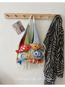 Gedetailleerd overzicht van de kleurrijke gebreide tas met 3D-visaccenten aan de wandhaak.