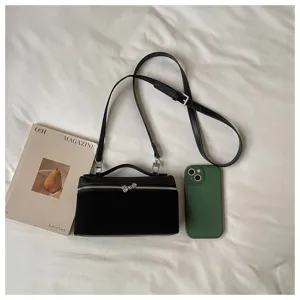 Bolso cruzado vanity negro para mujer, diseño minimalista con asa y correa ajustable.