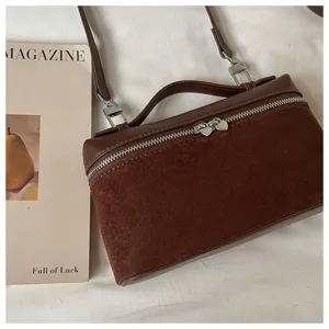 Detalle de primer plano del bolso bandolera marrón de mujer en cuero y terciopelo.