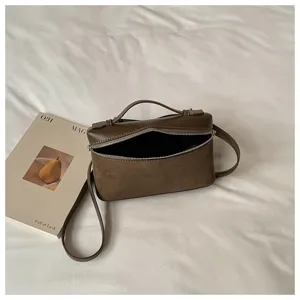 Bolso bandolera marron tipo caja, diseno elegante de ante y cuero con asa superior.