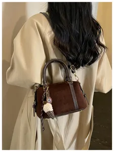 Vintage brown suede crossbody bag for women, retro chic shoulder handbag with cute charm detail.