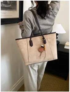 Gedetailleerd overzicht van de vintage suède shopper tas met grote capaciteit en bruine hengsels.