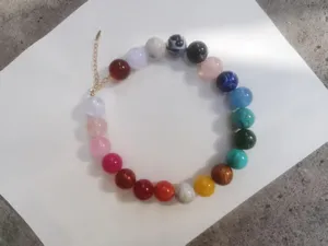 Dettaglio in primo piano della collana di perle di resina colorata con catena di estensione.
