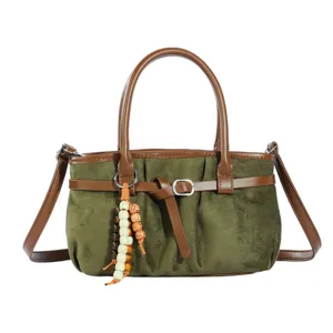 Sac bandoulière rétro en suédine vert olive avec bordure en cuir marron et perles.