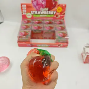 Transparent strawberry squishy toy detail view, showing soft texture and elastic squeeze design.