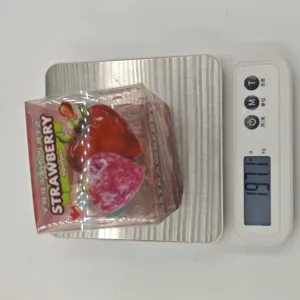 Transparent strawberry squishy toy detail shot showing product packaging and weight scale.