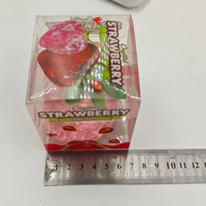 Detailed view of the clear strawberry squishy toy in transparent box with scale ruler.