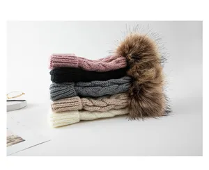 Detailansicht der einfarbigen Kinder Strickmütze mit Zopfmuster und Fellbombe für Winter.