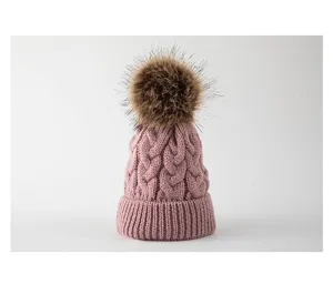 Rosa Kinder Strickmütze mit flauschigem Bommel und Zopfmuster für warme Wintertage.