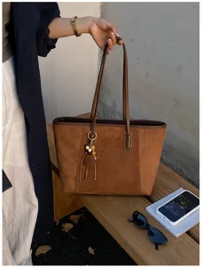 Bruine suède shopper voor dames, retro grote capaciteit schoudertas met bedelhangertje.