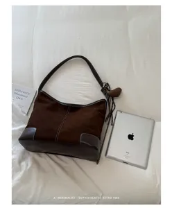 Bruine suède schoudertas detail met contraststiksels en vintage retro hobo designstijl.