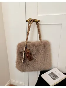 Bolso tote de felpa marrón en detalle, bolso esponjoso con colgante de oso y asa trenzada.