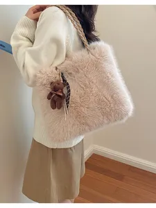 Vista detallada del bolso tote de peluche suave con colgante de oso y correa trenzada.