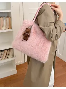 Detalle del bolso rosa de peluche suave con asa trenzada y bonito osito colgante.