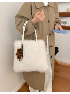 Detalle de bolso tote de felpa blanca con textura de piel sintética y lindo dije de oso.