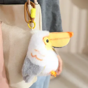 Cute plush bird pendant detail shot, fluffy animal toy hanging on a stylish canvas bag.