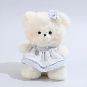 Süße weiße Plüschbärpuppe mit blauem Blumenkleid und Haarschleife, Stofftier Detailansicht.