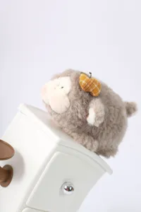 Nahaufnahme des niedlichen flauschigen Schaf Plüschtiers auf weißem Schreibtischaccessoire.