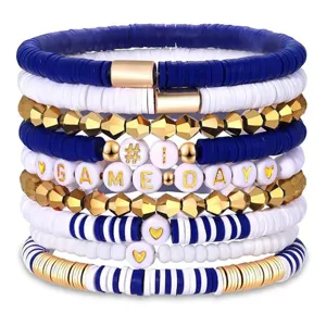 Detailansicht der gestapelten blau-weißen Tonperlen-Armbänder mit goldenen Akzenten und Buchstaben.