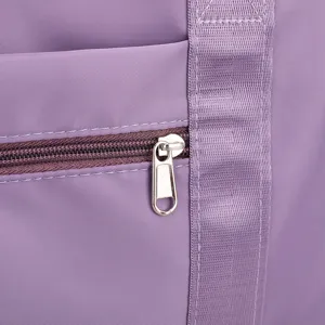Close-up detail of purple travel fitness bag zipper and strap texture, durable fabric.