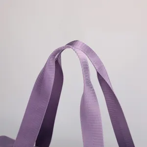 Close up view of durable purple fabric bag handles showing fine woven texture details.