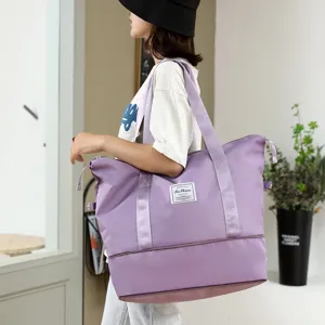 Detail view of the large capacity purple travel duffel bag showcasing sturdy double handles.