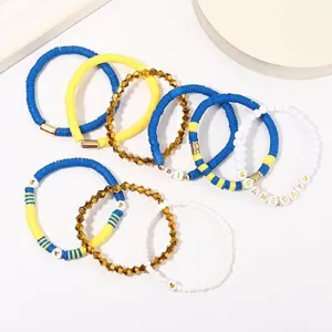 Game Day Perlenarmband Set mit blauen gelben Tonperlen und metallischen Anhängern.