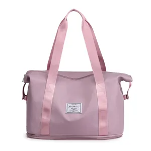 Detailed travel duffel bag with pink webbed straps, fashion label patch, and expansion base.