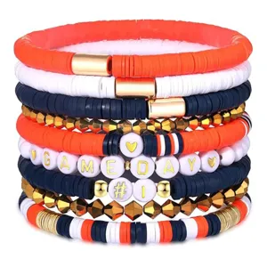 Detailaufnahme stapelbarer Tonperlen Armbänder mit goldenen Abstands- und Buchstabenperlen.
