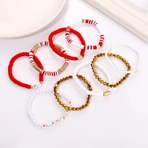 Detailansicht des rot-weißen Tonperlen-Armbandsets mit goldenen Metallperlen und Buchstaben.