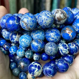 Gros plan détaillé de perles rondes en jaspe impérial bleu montrant des textures uniques.