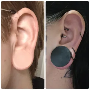Close-up view of soft silicone ear stretching plugs worn on ears, showing double flared design.