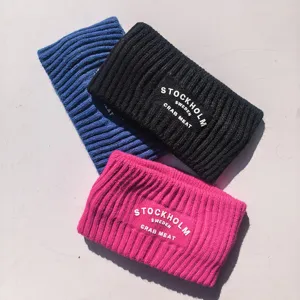 Vue détaillée de banderoles d'hiver tricotées épaisses en bleu, noir et rose avec des lettres.