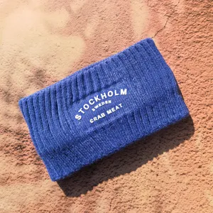 Vue détaillée du bandeau d'hiver en tricot bleu avec impression de lettres blanches, chaud.