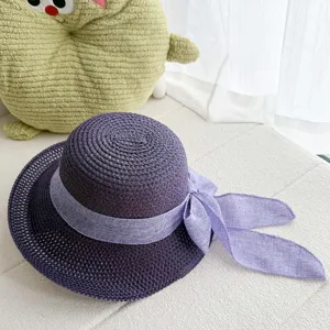 Gros plan sur les details du chapeau de soleil tisse violet d'ete avec un beau noeud elegant.