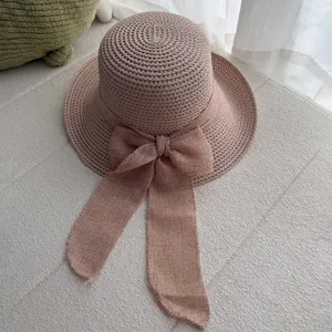 Gros plan détaillé d'un chapeau de paille tissé d'été pour femmes avec un grand nœud.