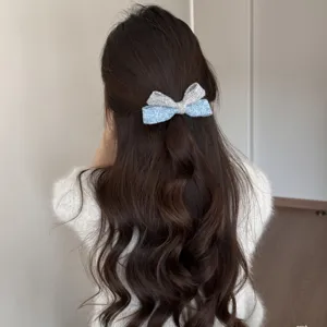 Vista dettagliata del fermaglio per capelli in tweed lavorato a maglia grigio blu.
