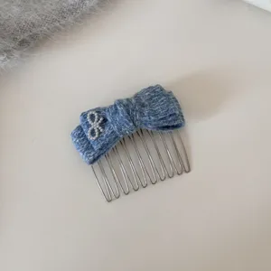 Pettine per capelli in maglia blu con dettaglio di perla, accessorio elegante donna.
