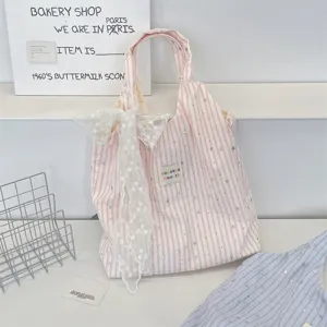 Pink striped star tote bag detail, casual canvas handbag with white lace bow and cute fabric label.
