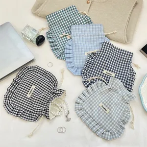 Detailed view of sweet plaid ruffle drawstring storage bags, portable fabric bags for underwear.