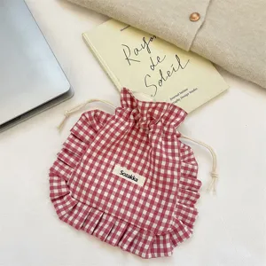 Close-up view of the red white gingham drawstring pouch with cute ruffles and small fabric label.