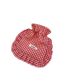 Red and white gingham drawstring bag with cute ruffles for portable daily storage needs.
