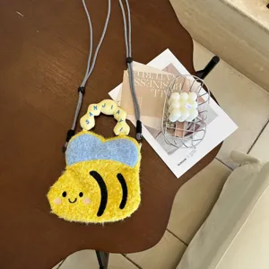 Vue rapprochée du sac téléphone abeille en peluche douce avec corps rayé et visage souriant.
