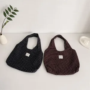 Detalle del bolso de hombro plisado con lunares, textura ligera y gran capacidad.
