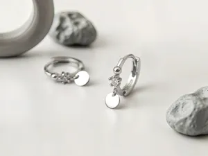 Kleine Creolen aus Sterlingsilber mit rundem Anhänger und funkelndem Zirkonia Detail Ansicht.