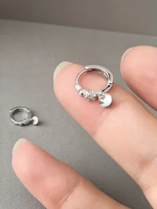 Silberne Creolen mit rundem Anhänger und zarten Steindetails für den täglichen eleganten Look.