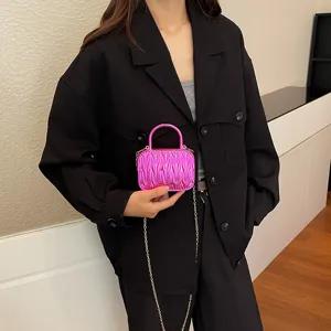 Detail view of the bright pink pleated acrylic box handbag, showcasing unique texture.