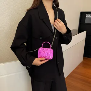 Pink pleated acrylic crossbody bag, chic mini box handbag with gold chain strap detail.