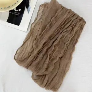 Vista detallada del pañuelo de voile arrugado marrón, con pliegues estrechos y textura suave.