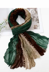 Exquisite detail view of the gradient crinkled scarf showcasing the unique green and brown texture.